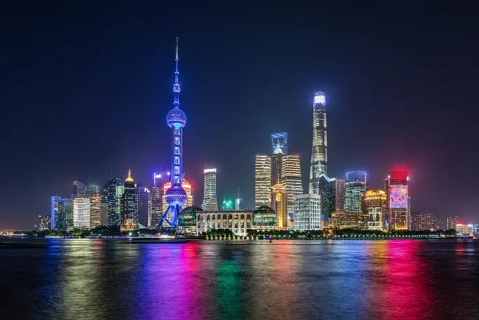 The Shanghai skyline lit up at night across the river