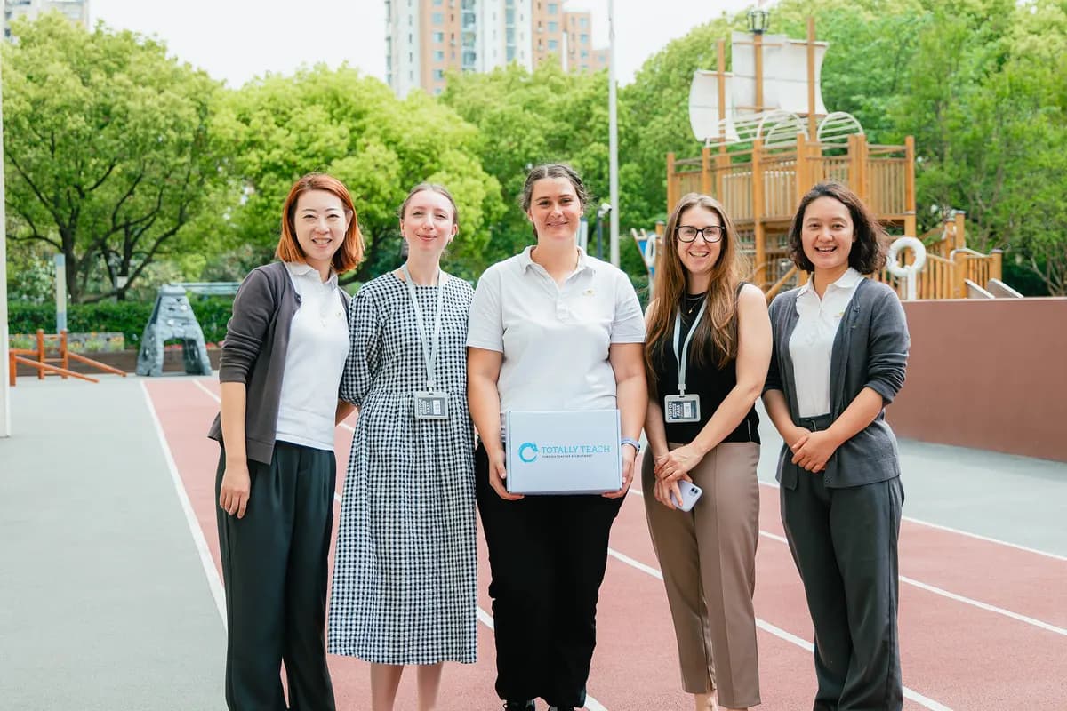 Five members of the Totally Teach team outside a school